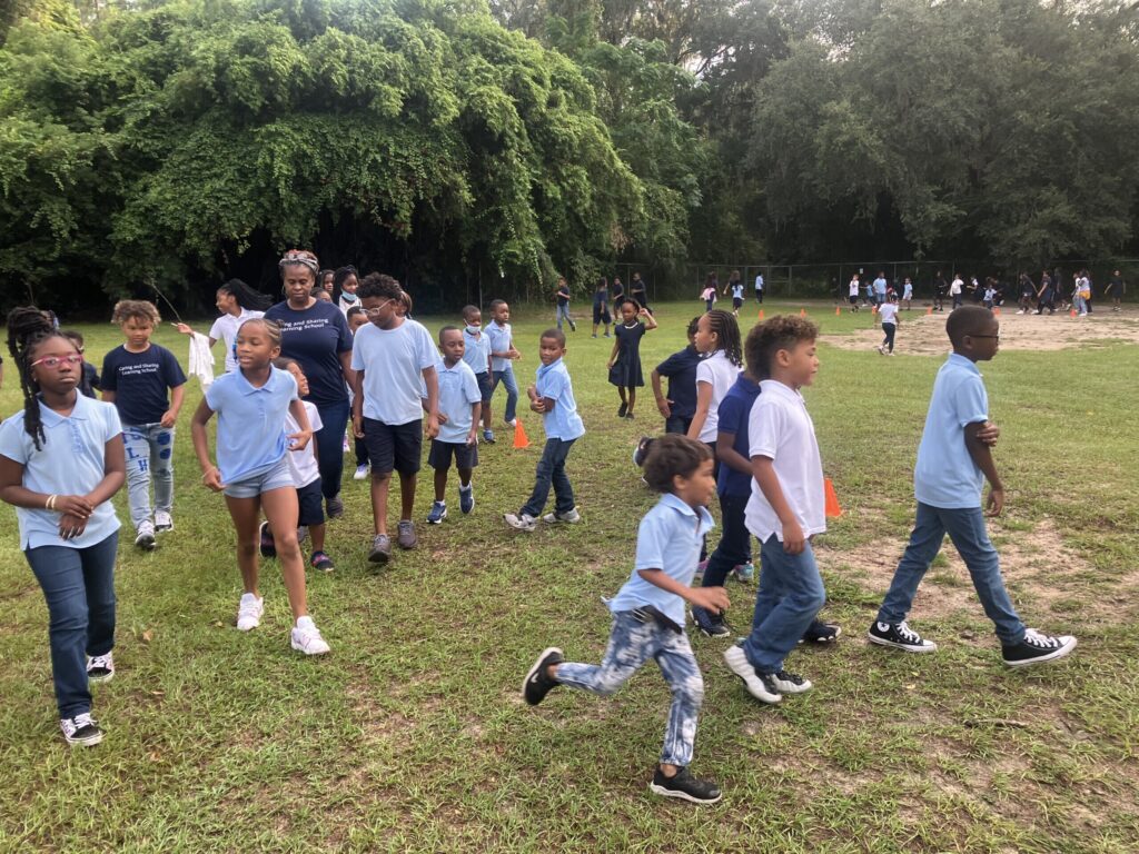 Schoolchildren and teachers participate in The Daily Mile at the Caring and Sharing Learning School in Gainesville, Florida.